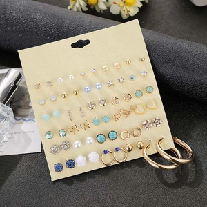 Detail view of 30-pair gold alloy earrings set with studs, hoops and faux pearls
