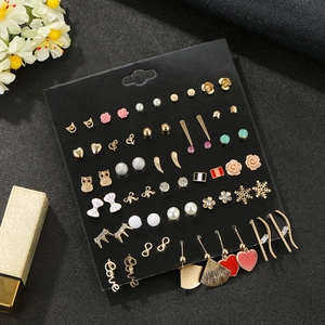 Detailed close-up of 30 pairs of mixed alloy stud earrings on a professional black card