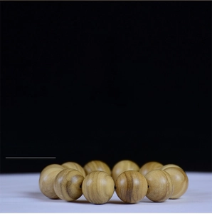 Macro detail of natural Agarwood prayer beads with organic oil grain texture