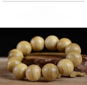 Macro view of polished wooden prayer beads showing fine grain texture on a carved stand