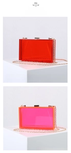 Detail view of transparent acrylic clutch bags in red and pink with gold metal chains