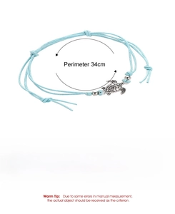 Detail showing hand-woven light blue rope anklet with silver sea turtle and size specs