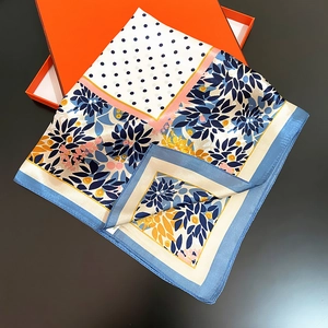 Élégant foulard en soie aux imprimés feuilles et pois sur une boîte cadeau orange chic