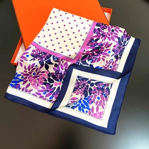 Vue détaillée d'un foulard en soie à motif de feuilles près d'une boîte cadeau orange