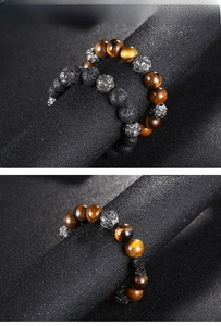 Detail of tiger eye and lava stone beaded bracelets with silver alloy accent beads