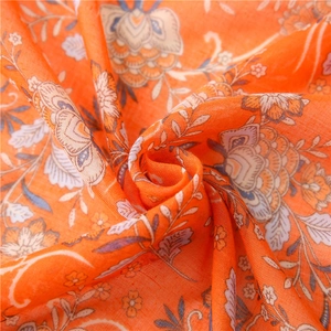 Macro view of orange floral scarf fabric with bohemian pattern and lightweight texture
