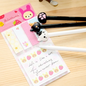 Flat lay of cute cartoon cat paw pens with a pink Rilakkuma sticky note stationery set