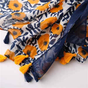 Close-up of bohemian floral cotton linen scarf with soft tassels and artistic yellow prints