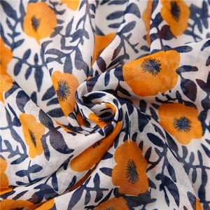 Detailed macro view of bohemian floral cotton linen fabric with intricate orange flower patterns