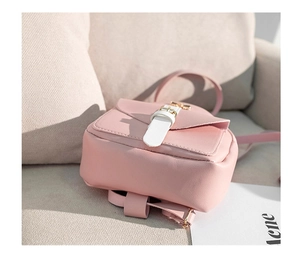 Close-up of pink mini leather backpack featuring a flap cover and gold metal buckle