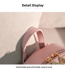 Detail of pink PU leather backpack featuring dual golden butterfly shaped zippers