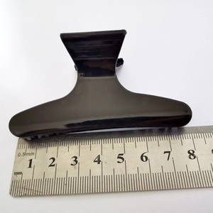 Molletta per capelli nera 8cm stile farfalla su un righello per la misurazione