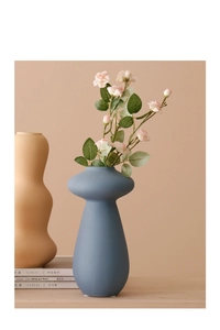 Jarrones artísticos de cerámica mate en azul y beige con rosas en una decoración moderna