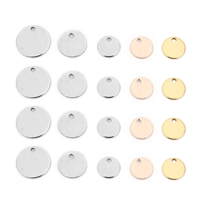 Flat lay of circular stainless steel tags in gold, silver, and rose gold finishes