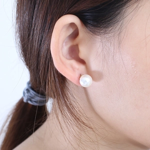 Boucles d'oreilles perles élégantes en plaqué or 18 carats portées sur un mannequin