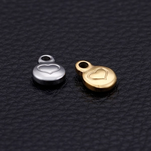 Polished silver and gold stainless steel round pendants with heart motifs on leather