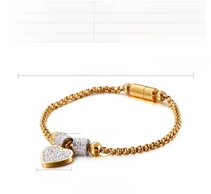 Détail du bracelet cœur en acier inoxydable doré avec breloques zircone et fermoir magnétique