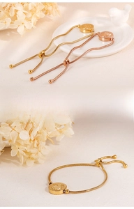 Detail of adjustable Hamsa hand snake chain bracelet in gold and rose gold finishes