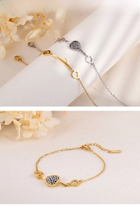 Detail of gold and silver heart bracelets with pavé crystals and hollow charms