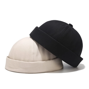 Detail of minimalist cotton docker caps showing six-panel stitch and folded brim texture