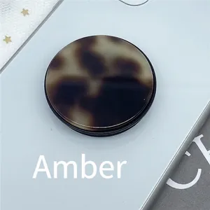Close-up of a round tortoise shell phone socket with amber patterns on a mobile back