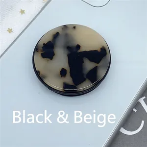 Collapsible phone grip with black and beige tortoise shell pattern on a white phone case