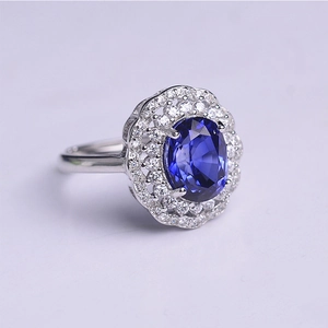 Macro shot of oval blue sapphire ring with double halo diamonds and silver band