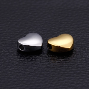 Polished heart shaped stainless steel beads in silver and gold on leather