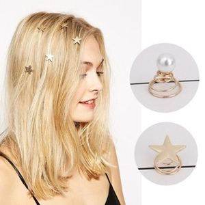 Detail of star and pearl spiral hair pins styled on blonde hair for a festive look
