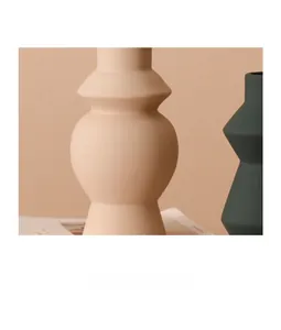 Detailweergave van matte keramische vazen in beige en donkergroen met geometrisch ontwerp