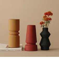 Close-up van matte Morandi keramische vazen in mosterdgeel, baksteenrood en zwart