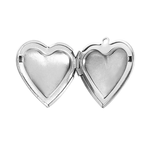 Macro shot of an open silver heart-shaped locket pendant with empty photo frames