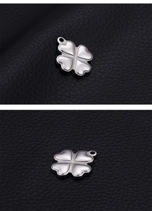 Macro shot of silver four-leaf clover pendant crafted from polished stainless steel