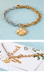 Détail du bracelet trèfle bicolore argent et or sur une carte avec fond bleu texturé
