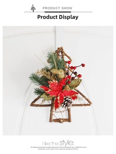 Detail of wooden Christmas wreath with pine cones and red poinsettia on white door