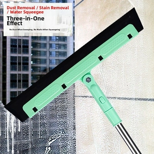 Close-up of a 3-in-1 mint green squeegee cleaning a glass window with water droplets