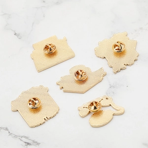 Detailed view of 5 golden metal brooch backs with secure clutch butterfly clasps