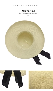 Detailed view of beige straw sun hat featuring close-up texture and black chiffon bow