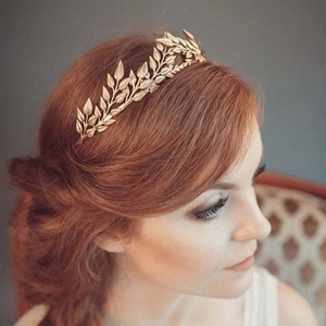 Elegant gold leaf bridal tiara headband for wedding hair styling on a red-haired model