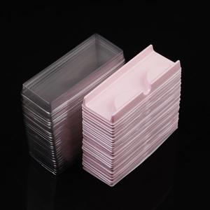 Detailed stack of clear and pink false eyelash packaging boxes with inner trays