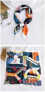 Detailed view of square silk scarf featuring abstract geometric patterns and smooth texture