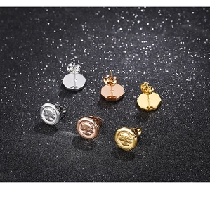 Detailed view of tree of life earrings in silver, rose gold, and gold on black background