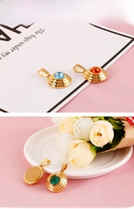 Close-up of gold stainless steel round pendants with colorful zircon stone inlay