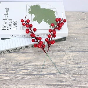 Artificial red berry stems for Christmas DIY decor on a rustic wooden background