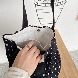 Dettaglio interno della borsa a pois con chiusura magnetica e tasca interna