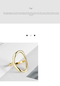 Detailed macro shot of an irregular hollow oval gold ring on a white book page