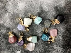 Macro shot of colorful natural stone pendants with gold plated clasps on grey fur