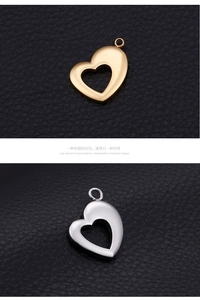 Detail of heart-shaped hollow pendants in gold and silver finish on black leather texture
