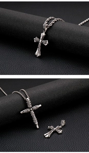 Detailed close-up of retro stainless steel gothic cross pendants for men on dark leather