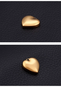 Macro view of gold heart-shaped metal pendant showing smooth finish on black leather